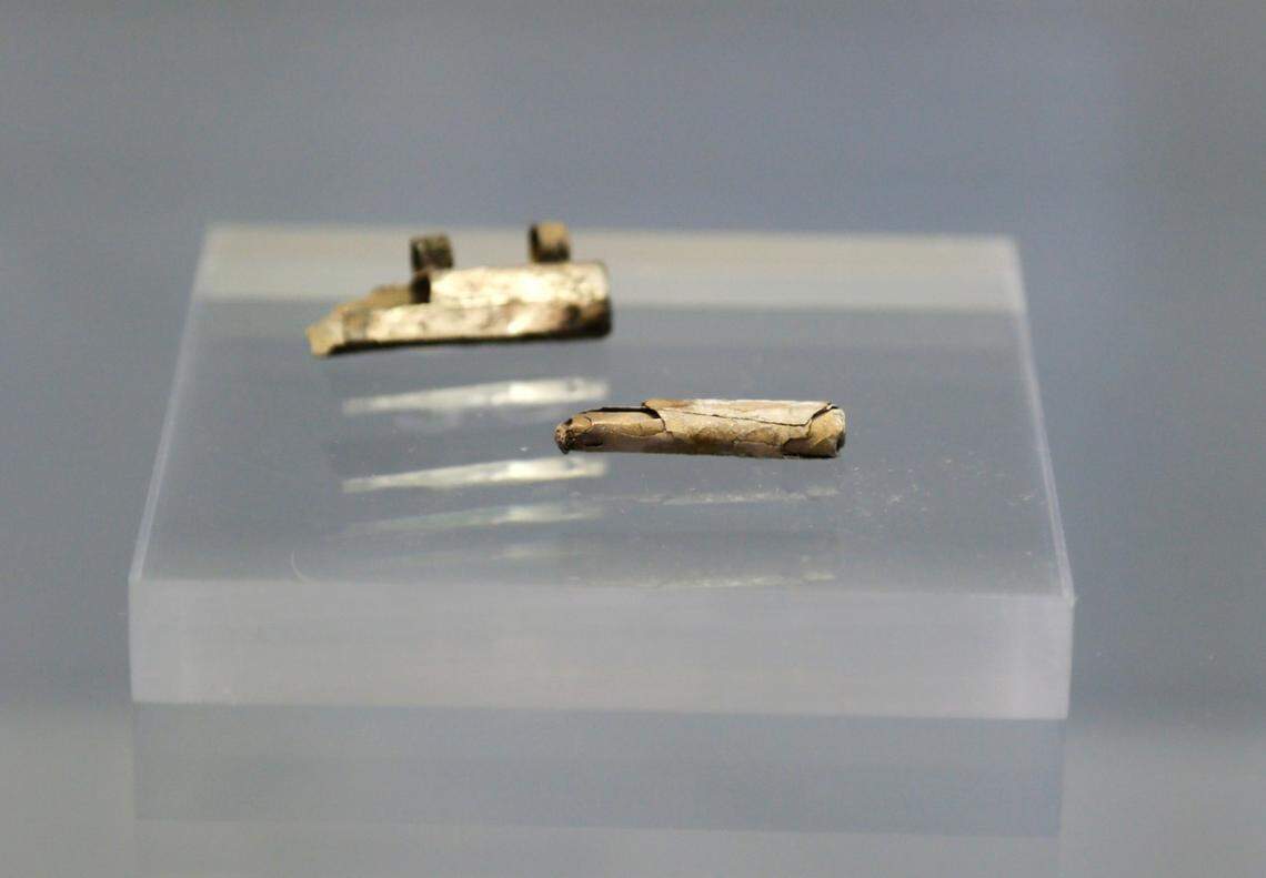 The 1,750-year-old amulet (back) and scroll (front) as seen during a news conference.