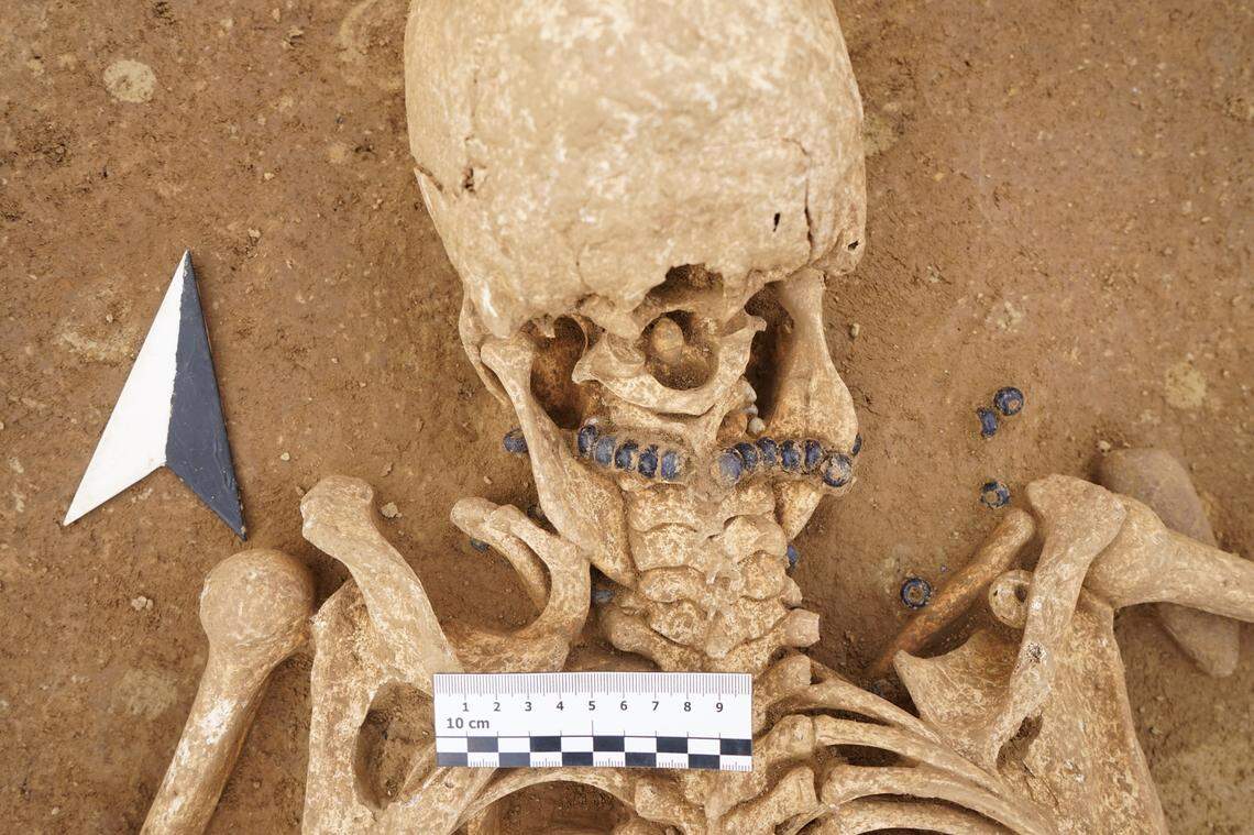 Experts found the remains of a woman wearing a glass-beaded necklace buried with a young girl, officials said.