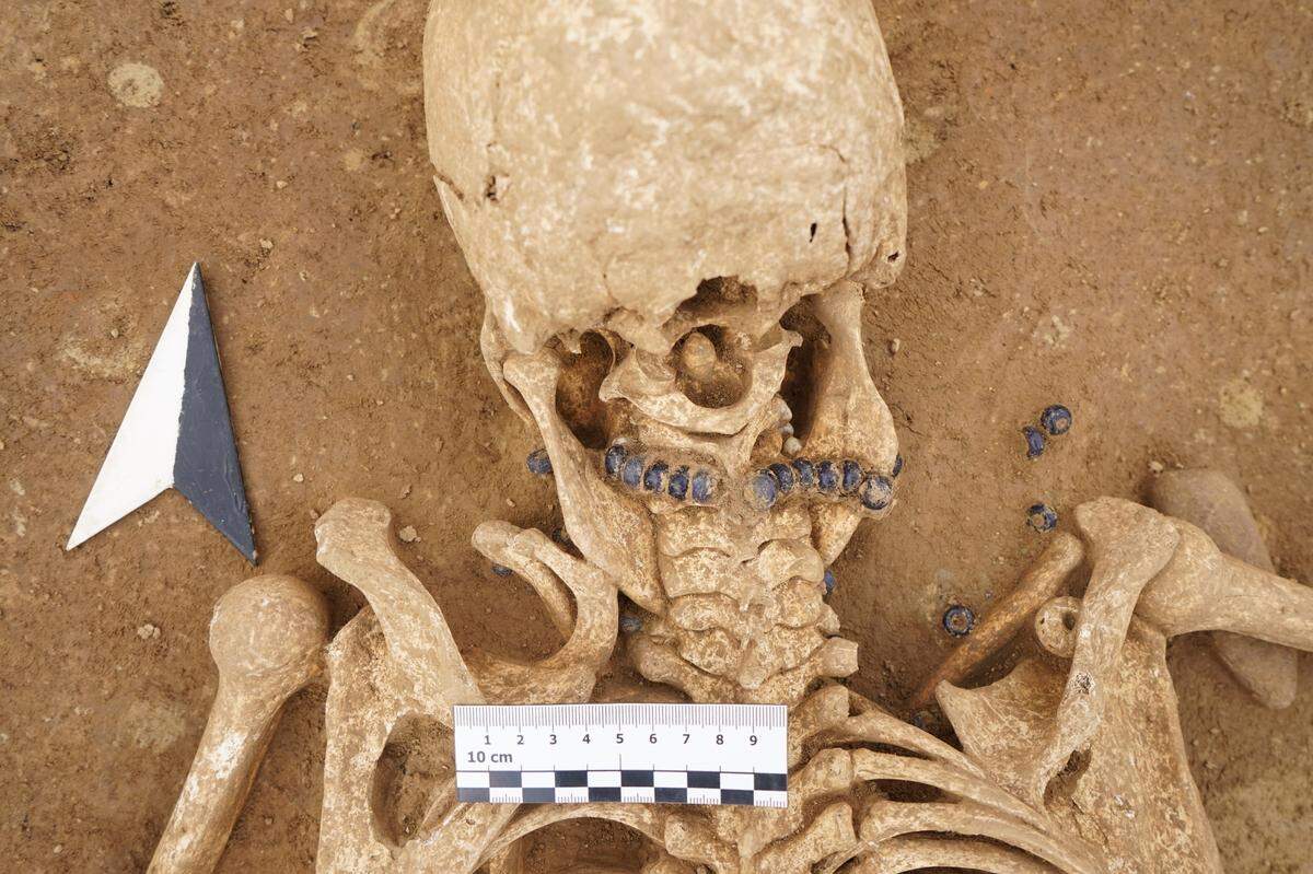 Experts found the remains of a woman wearing a glass-beaded necklace buried with a young girl, officials said.