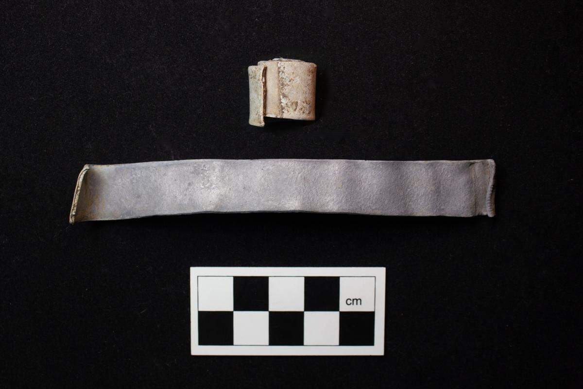 A rolled scroll sits next to an unrolled scroll.