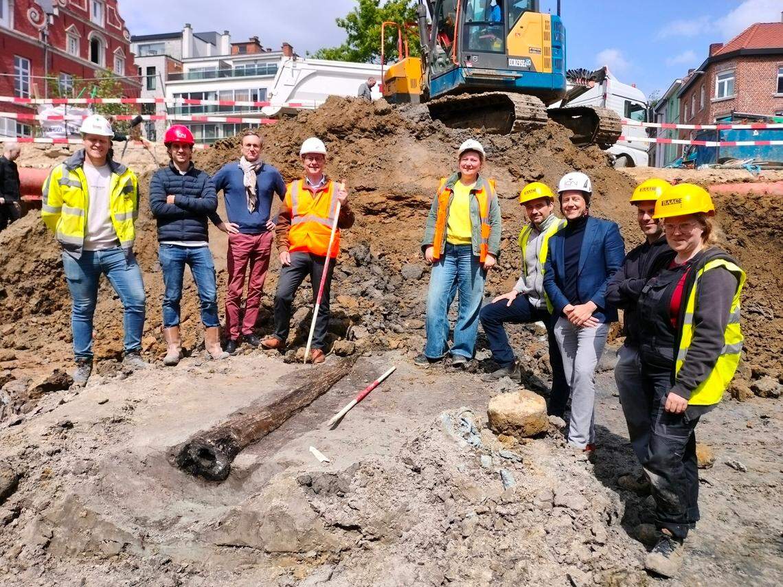 Archaeologists stand near the ancient Roman wooden water pipe found in Leuven.