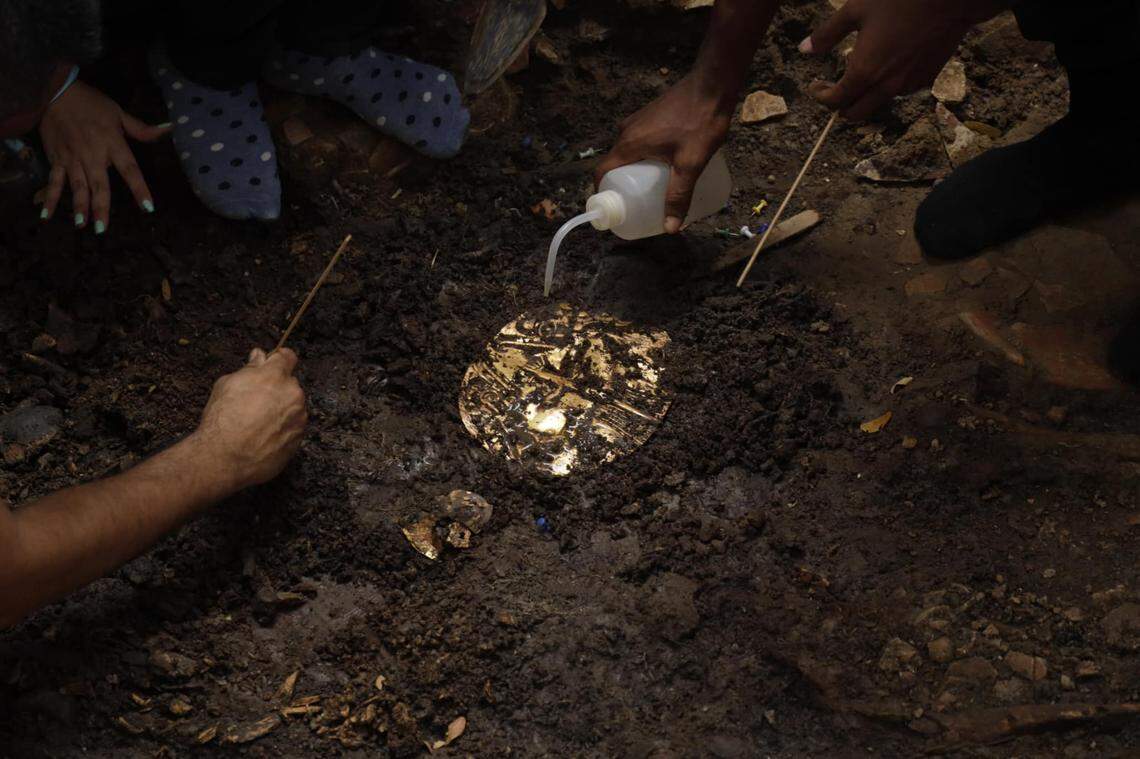 Archaeologists excavate a gold artifact found in the 1,200-year-old burial.