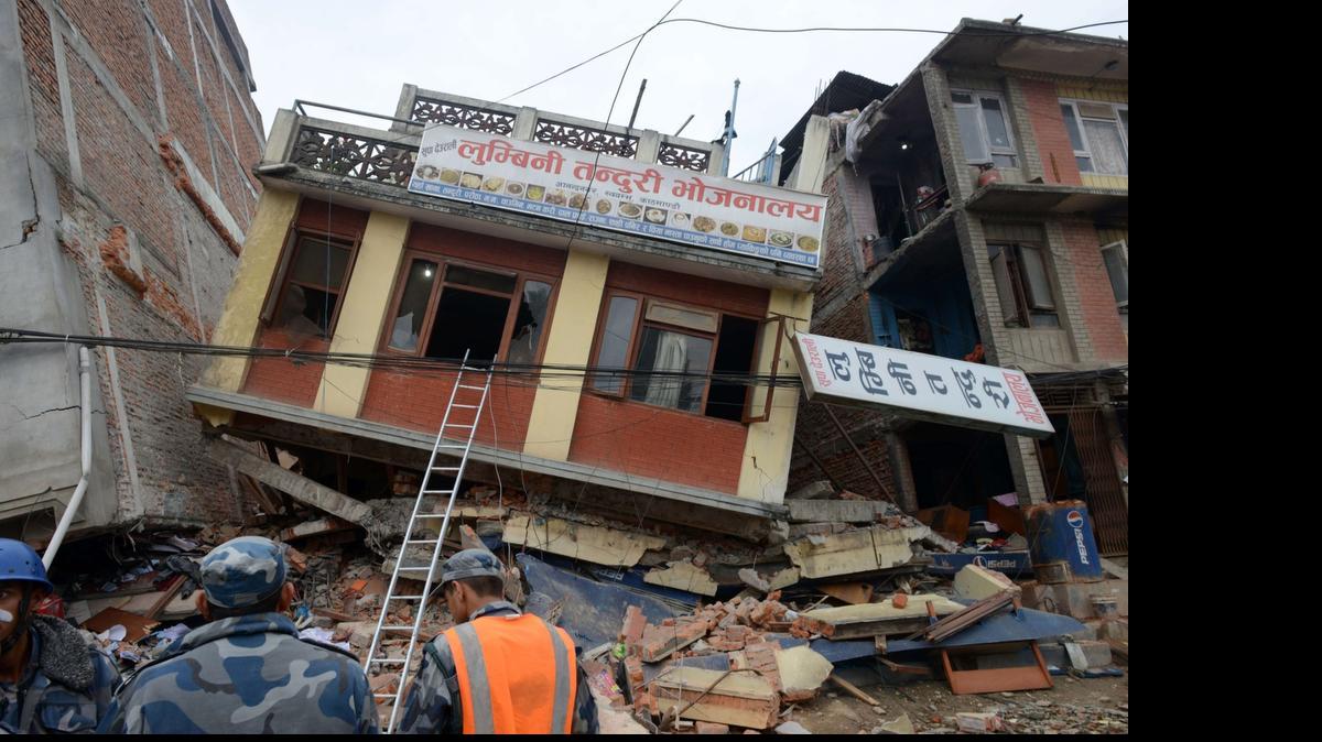 
Nepalese rescue personnel observe damaged buildings following an earthquake in Kathmandu on April 26, 2015. International aid groups and governments intensified efforts to get rescuers and supplies into earthquake-hit Nepal on April 26, 2015, but severed communications and landslides in the Himalayan nation posed formidable challenges to the relief effort. As the death toll surpassed 2,000, the US together with several European and Asian nations sent emergency crews to reinforce those scrambling to find survivors in the devastated capital Kathmandu and in rural areas cut off by blocked roads and patchy phone networks. 
