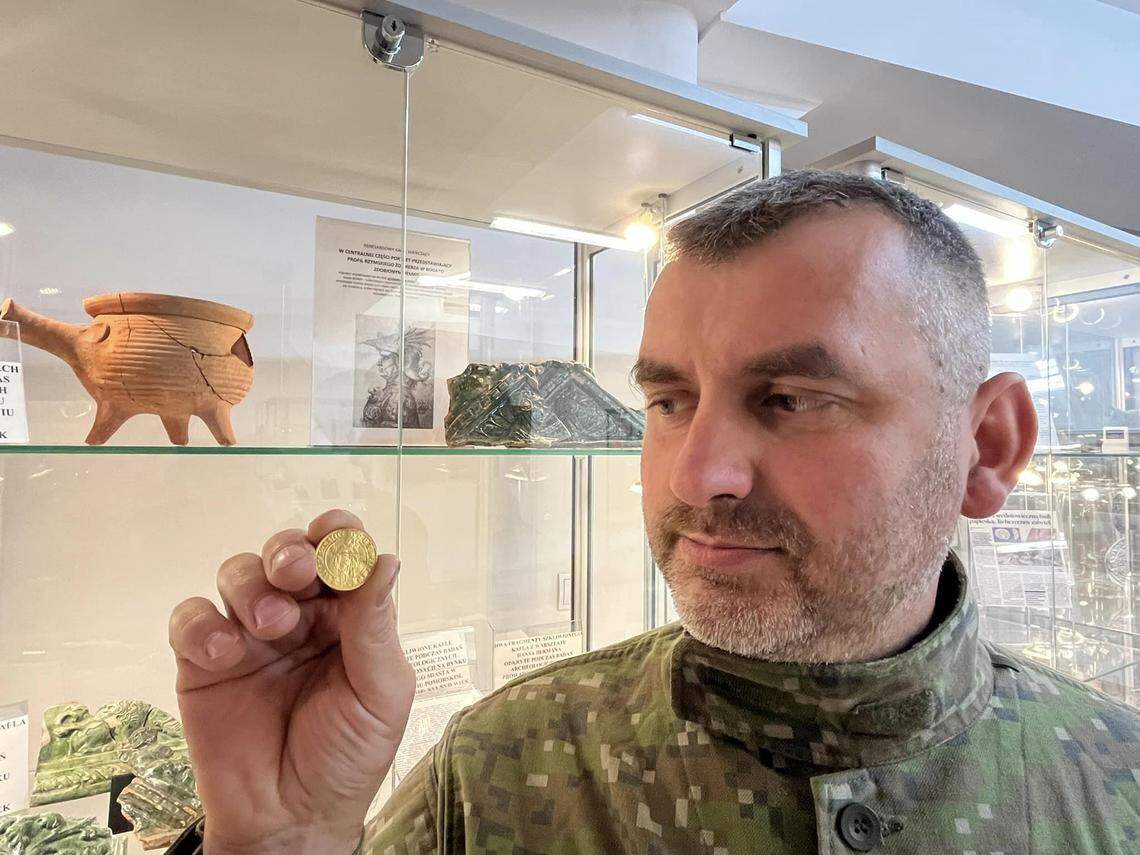 Daniel Kwaśniak vel Kwasniewski holds the medieval gold coin he found near Kamień.
