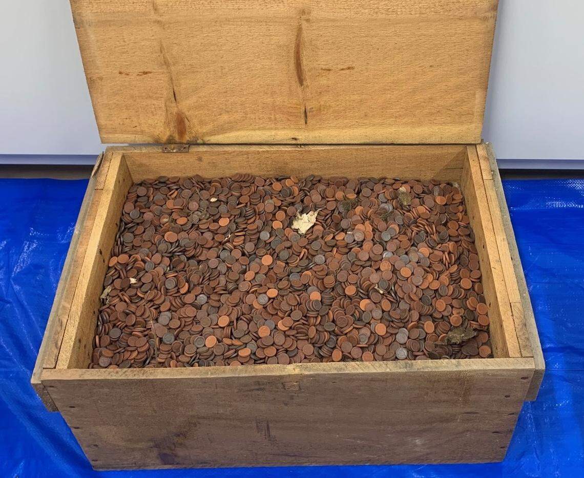 A wooden box filled with ceramic “phantom” coins.