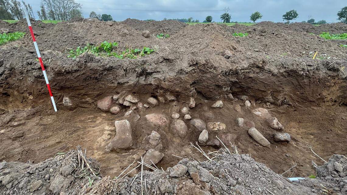 Archaeologists in Denmark dug into a rock pile and uncovered an ancient Neolithic grave with teeth and daggers, photos show.