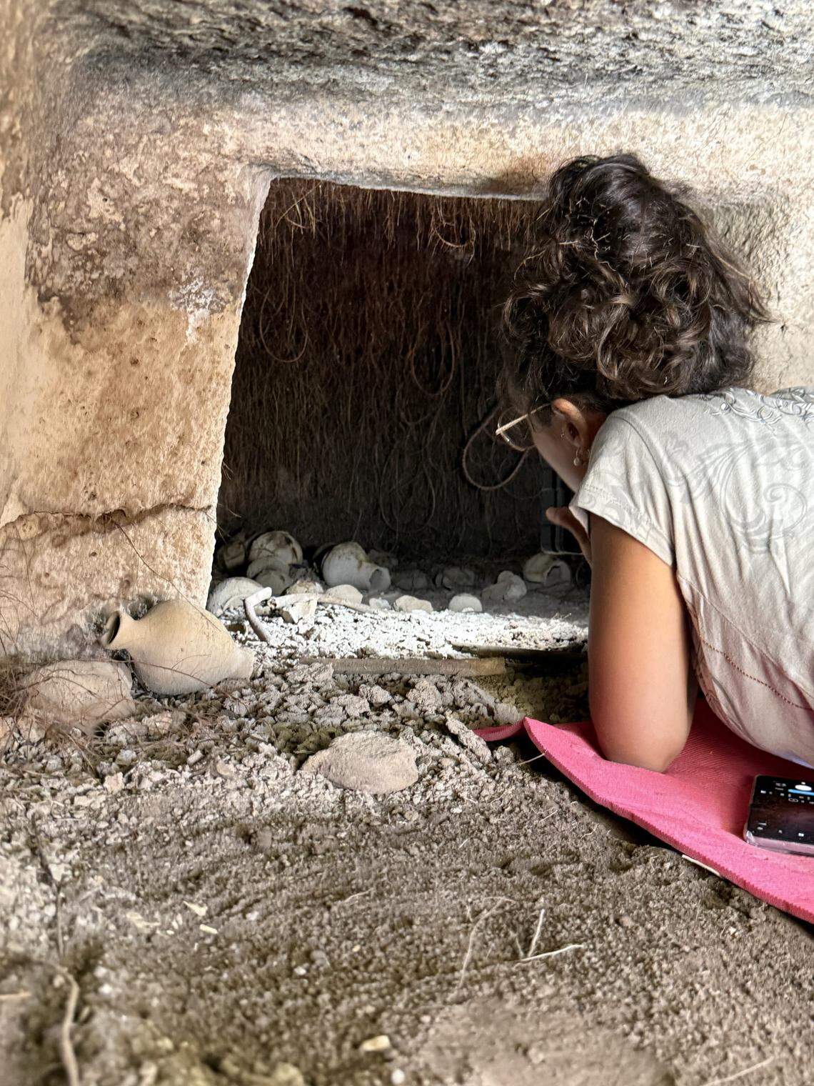 An archaeologist works on a section of Tomb XX.