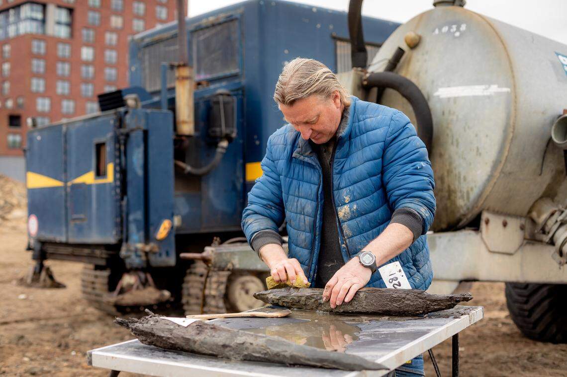 A worker cleans a 1,900-year-old wooden post.