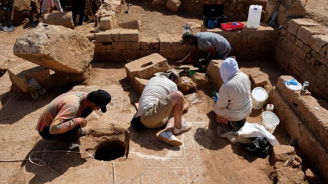 Archaeologists excavate the mosaic (right) and look into an underground cistern (left).