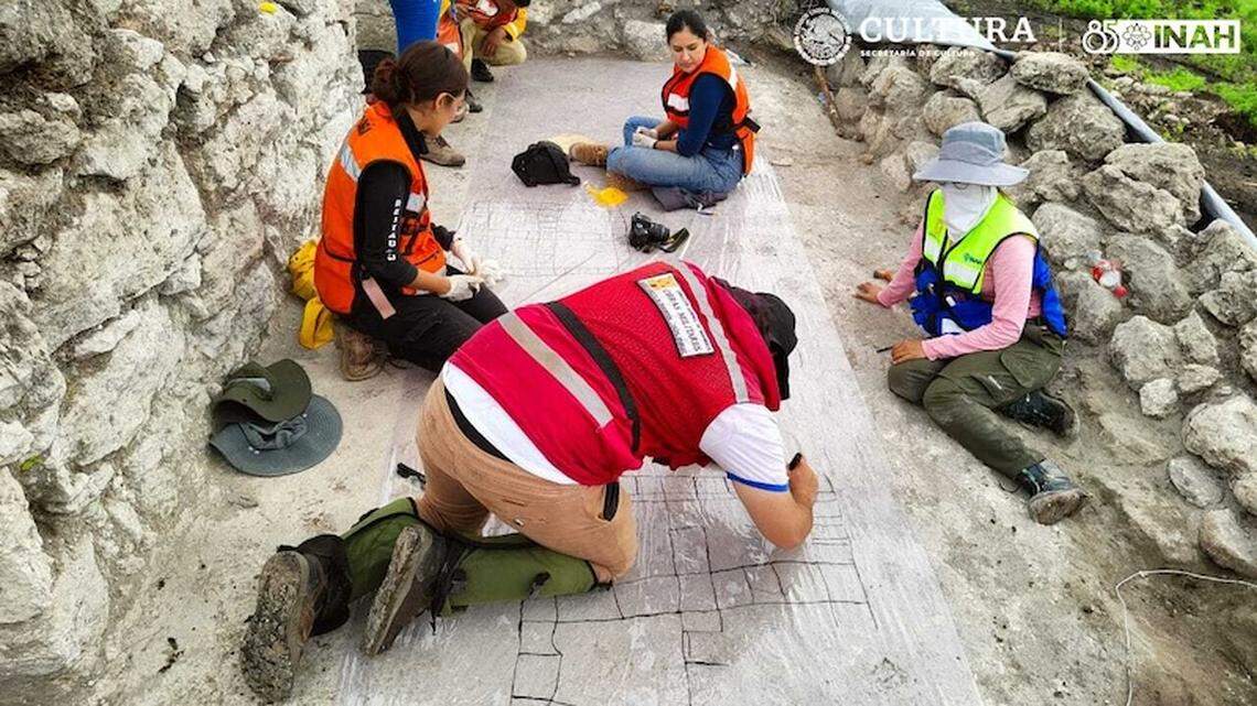 Archaeologists trace the ancient game boards on plastic during the excavations.