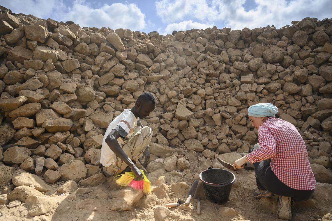 The research team excavates a cairn.