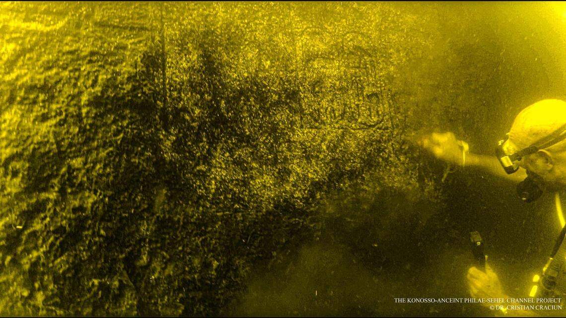 A scuba diving archaeologist uncovers an ancient carving.