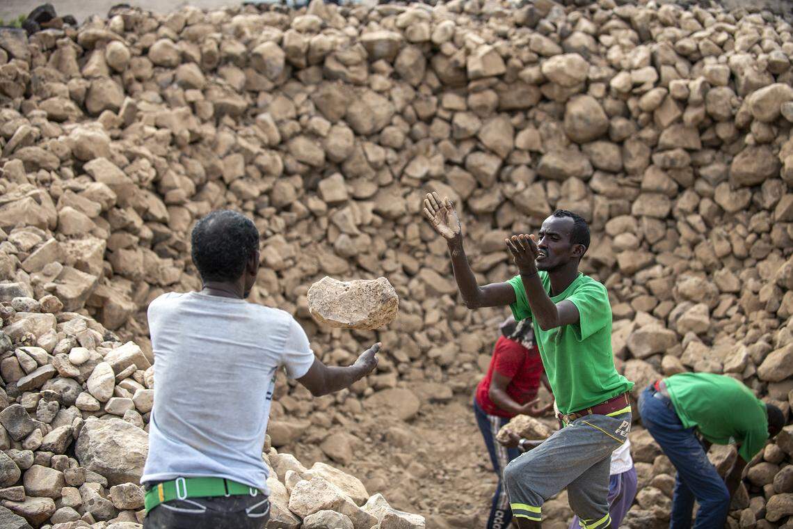 The research team excavates a stone cairn.