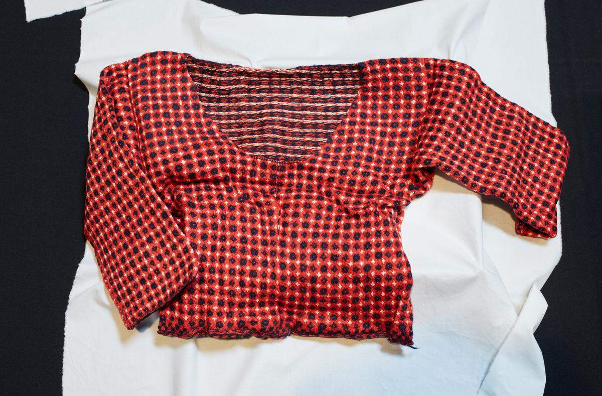 A close-up photo shows the 2017-year-old sweater flat on a table.
