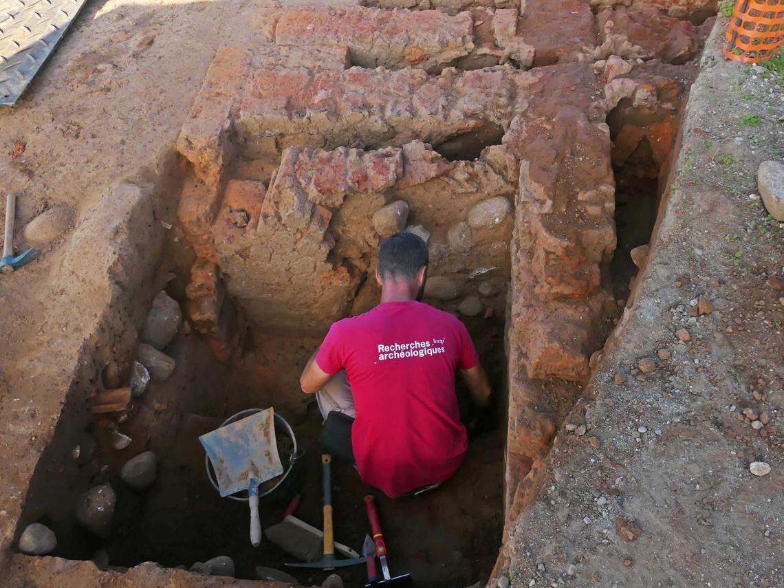 An archaeologist excavates the ancient kiln.