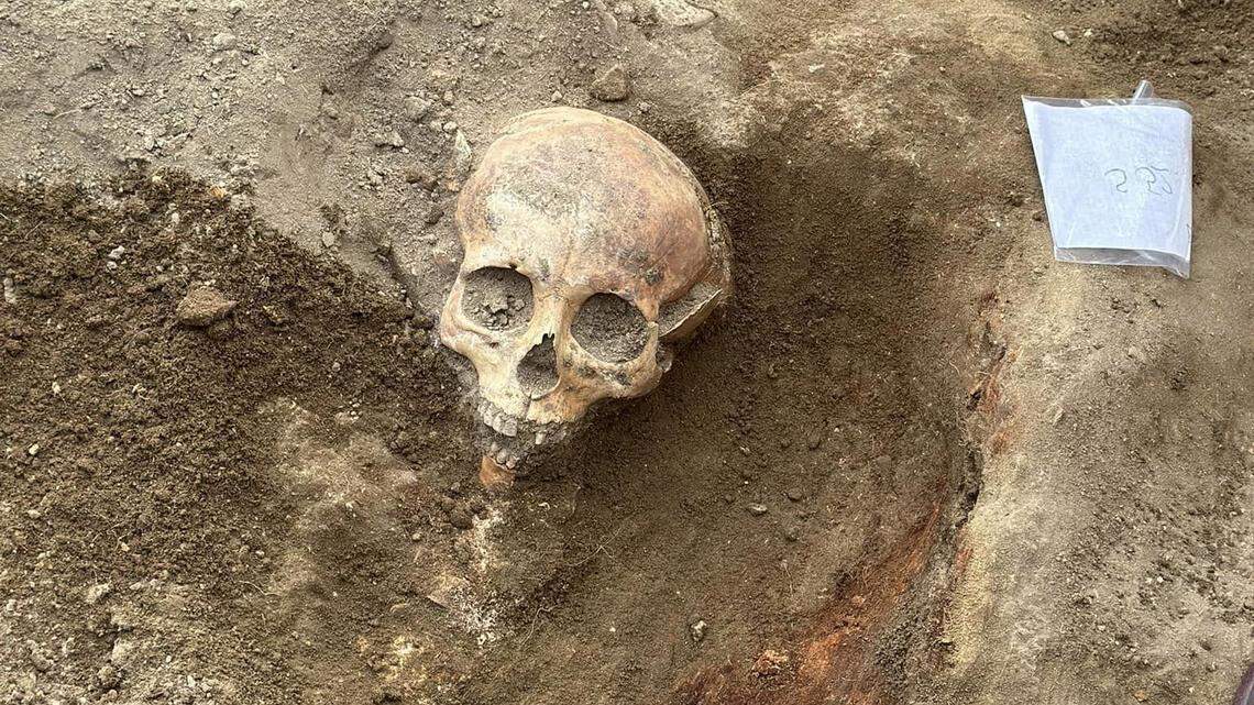 Archaeologists excavated the ruins of religious building and found a skeleton holding a 600-year-old silver communion set, photos show.