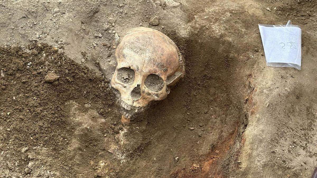 Archaeologists excavated the ruins of religious building and found a skeleton holding a 600-year-old silver communion set, photos show.