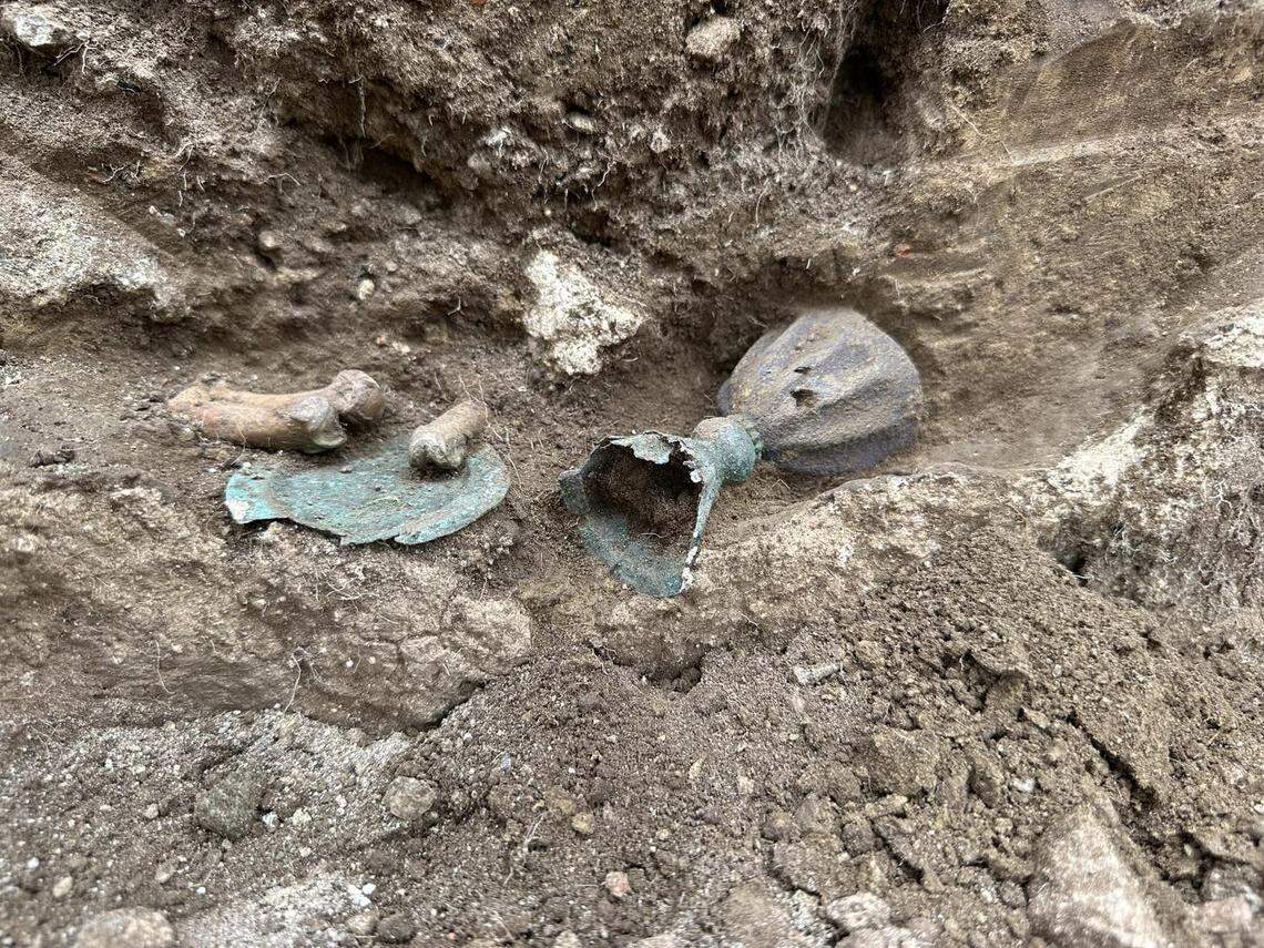 The 600-year-old chalice and plate still partially buried.