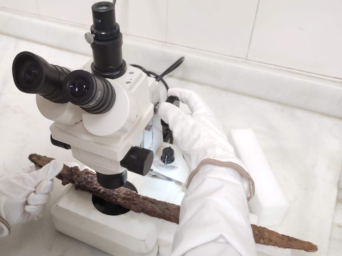 An archaeologist analyzes the 1,000-year-old weapon.