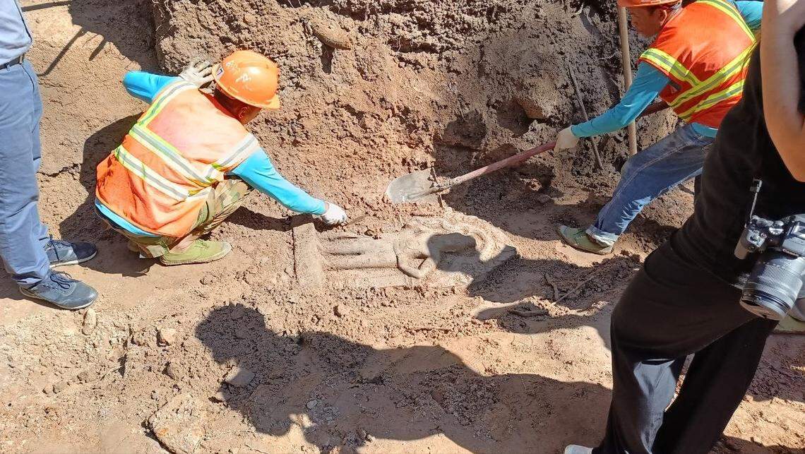 A partially buried 900-year-old statue as seen during excavations.