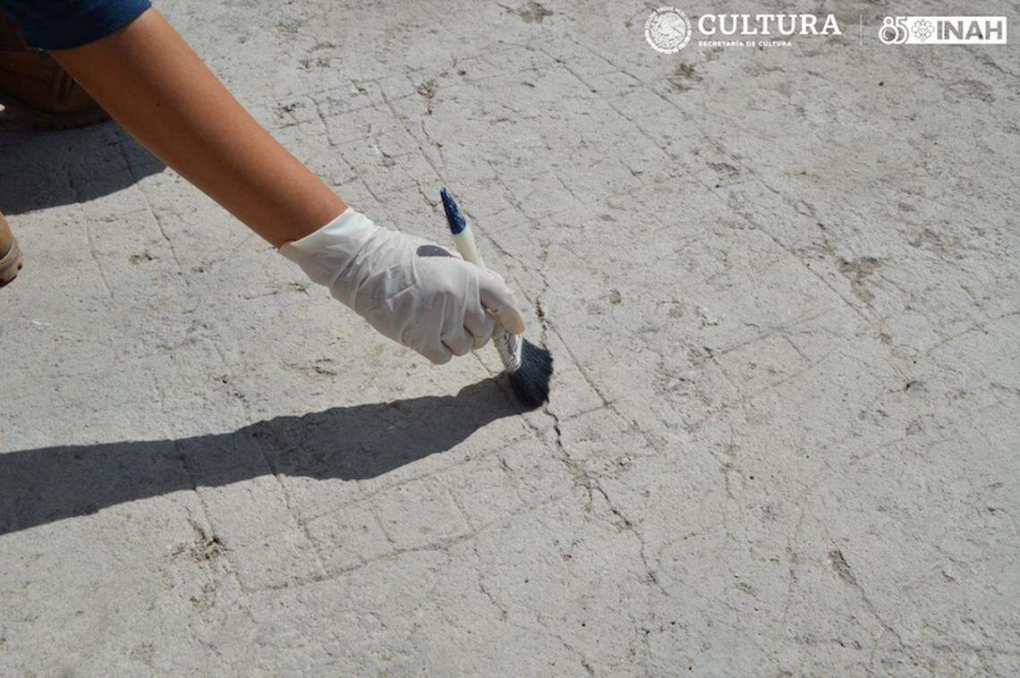 An archaeologist dusts off an ancient patolli game board.