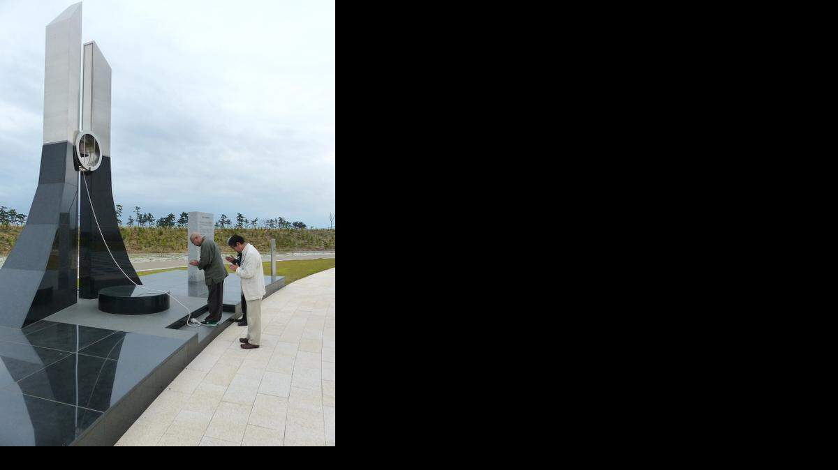 
PRAYER FOR VICTIMS: Zen priest Doryu Hioki and local officials pray at a memorial park commemorating tsunami victims.
