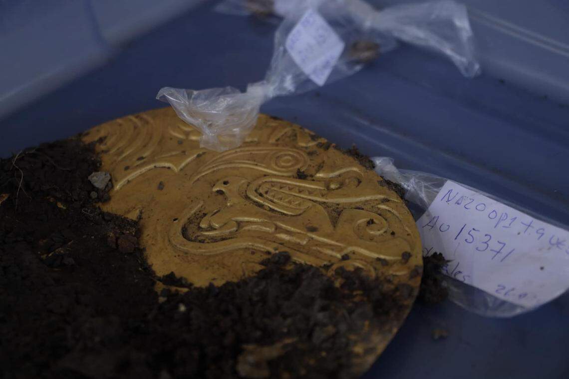 A close-up photo shows an intricate gold artifact found in the 1,200-year-old grave.