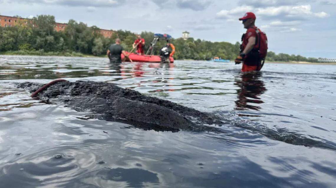 Volunteers found a submerged log in the Narew River identified by archaeologists as a historic 25-foot-long dugout canoe, photos show.
