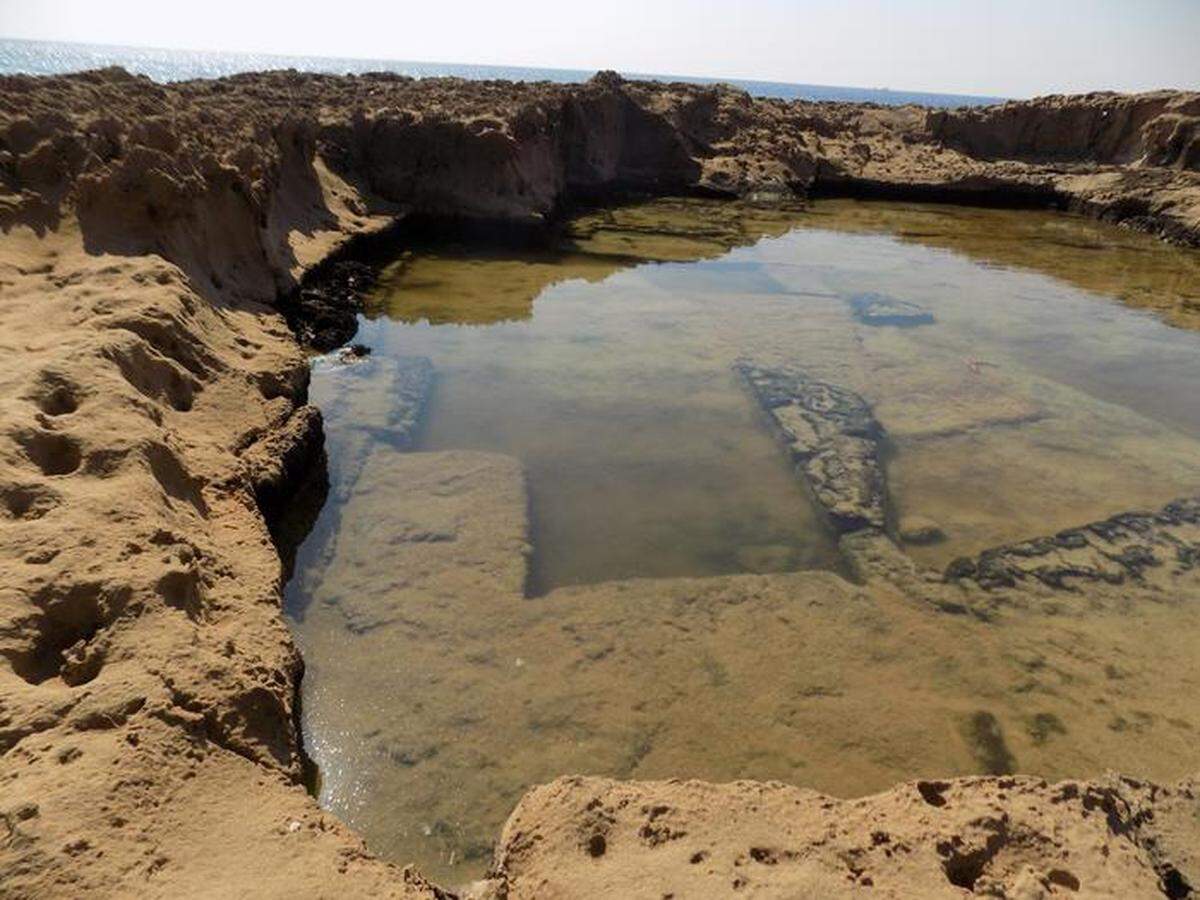 An ancient stone quarry where sections of rock are visibly missing.
