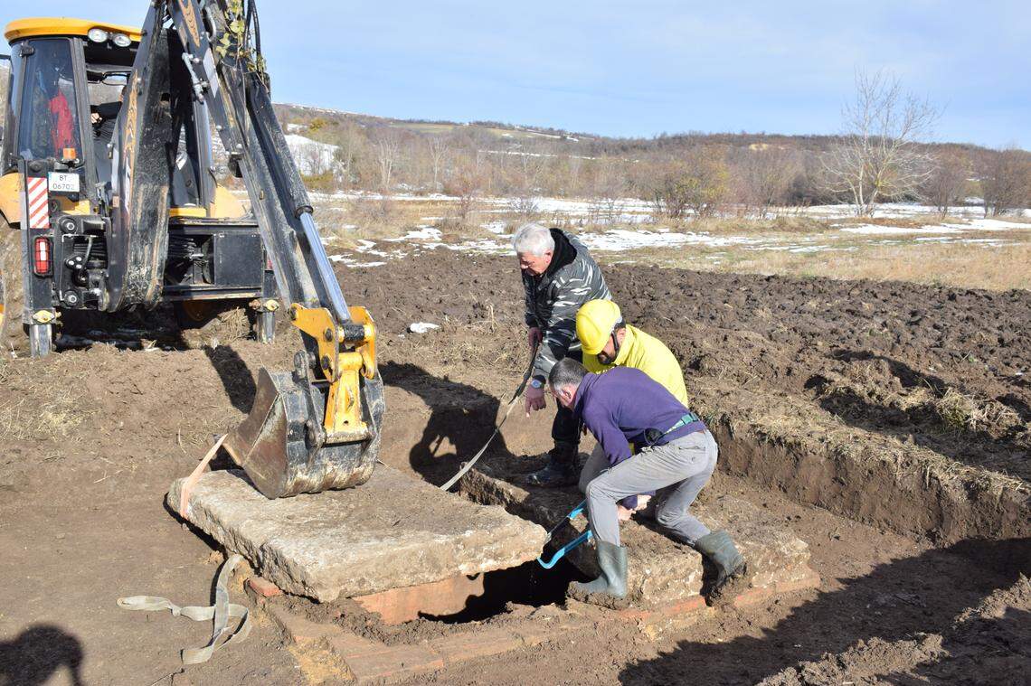 A group moves the stone slab off the top of the 1,700-year-old Roman tomb.