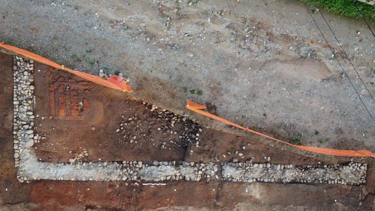 An aerial view shows the kiln (upper left) and outer L-shaped wall of the workshop.