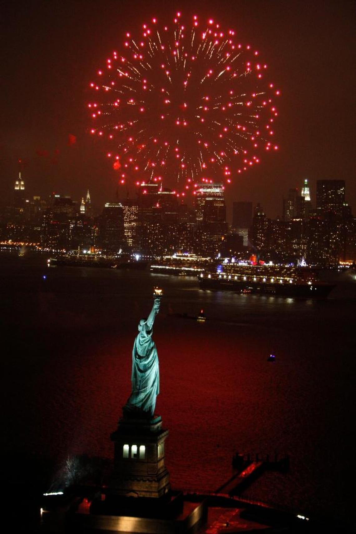 Fireworks light up the sky over New York harbor as the Queen Mary 2, right, Queen Victoria, center, and Queen Elizabeth 2 rendezvous near the Statue of Liberty in this Jan. 13, 2008, file photo in New York.