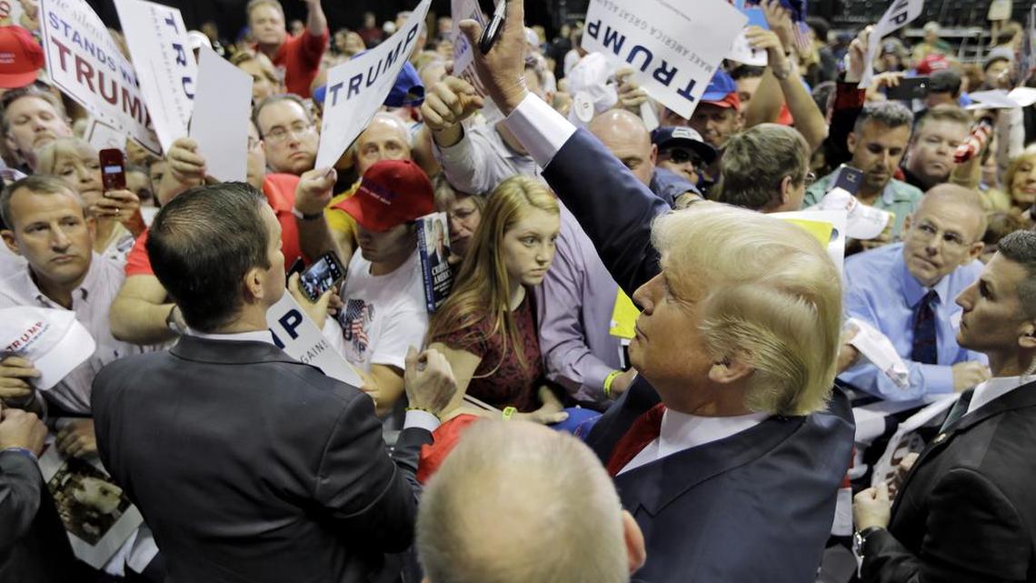 Republican presidential candidate Donald Trump waves at the crowd while signing autographs for supporters at a rally Friday in Tampa. At least 10,000 came out to USF’s Sun Dome.