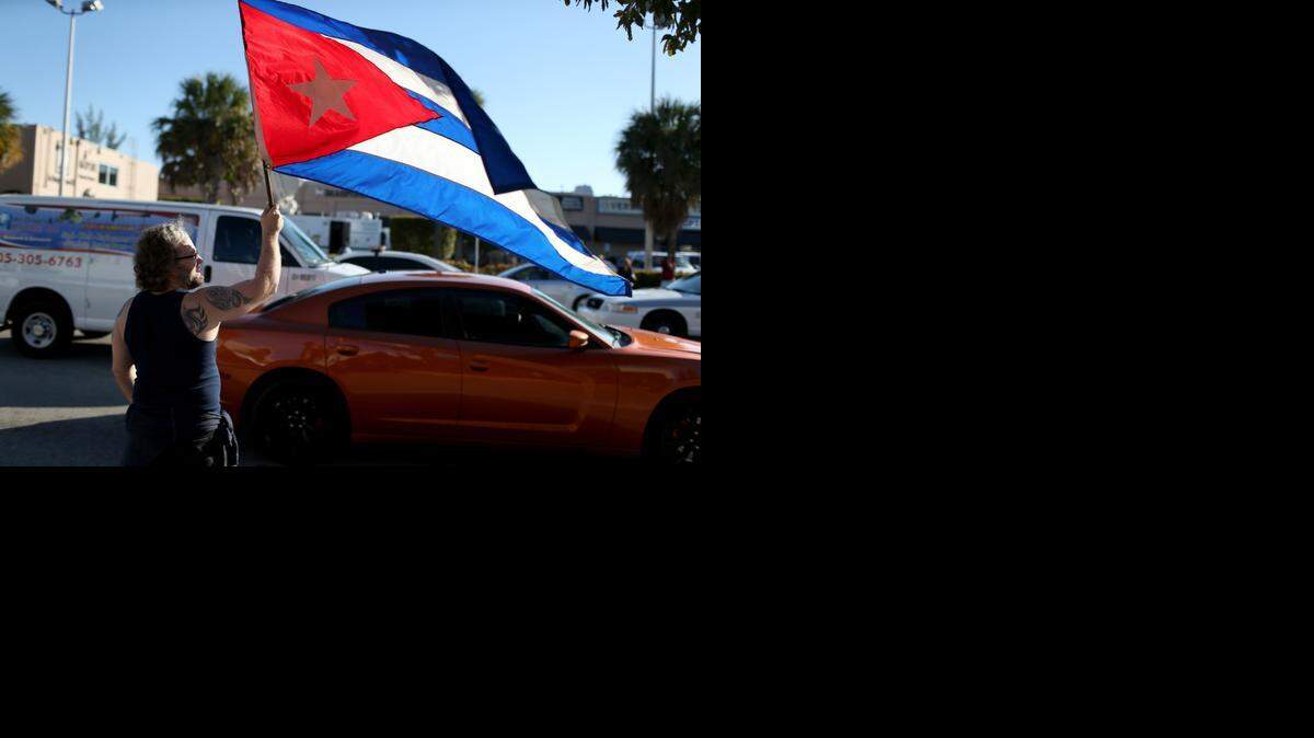 
Abdel Rodriguez holds a Cuban flag as he stands outside the Little Havana restaurant Versailles on Wednesday.

