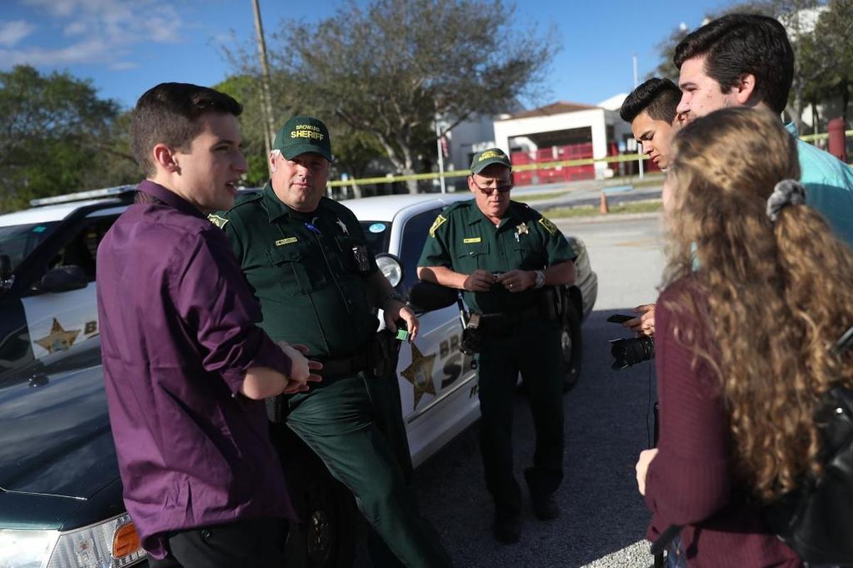 Cameron Kasky, in the purple shirt, and other students of Marjory Stoneman Douglas High School speak with Broward County Sheriff officers Brad Griesinger and Jamie Rubenstein.