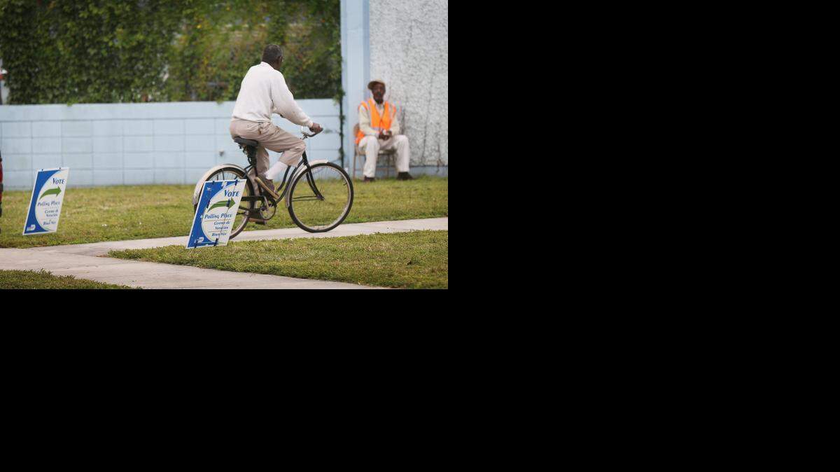 
A voter rides his bicycle up to his voting precinct at Agenoria S. Paschal / Olinda Elementary School in Brownsville on election day, Tuesday, Nov. 4, 2014.
