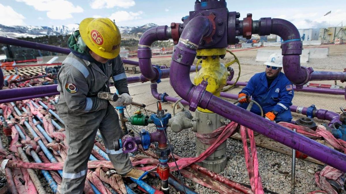 Workers tend to a well head during a hydraulic fracturing operation outside Rifle, Colorado, in March 2013.