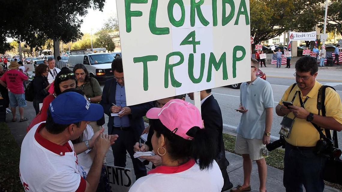 A group of supporters display a banner for candidate Donald Trump outside the University of Miami before a Republican presidential debate March 10.