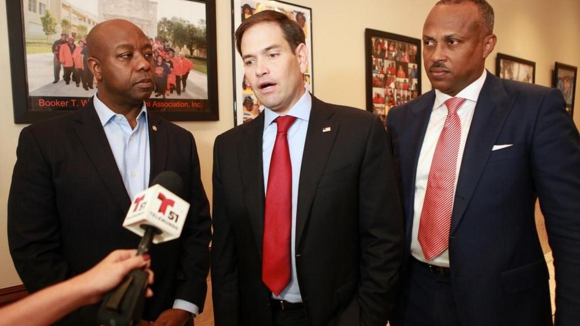 U.S. Sens. Tim Scott of South Carolina and Marco Rubio of Florida, and Pastor Gary Johnson, talk to the media after a meeting at Jackson Soul Food in Miami on Wednesday.