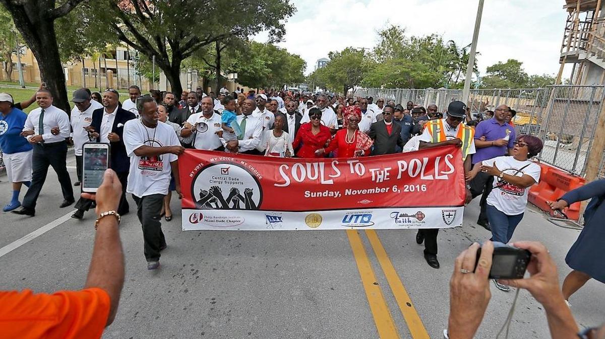 A crowd marches from the Greater Historical Bethel AME Church to the Miami-Dade County Hall early-voting site Sunday.
