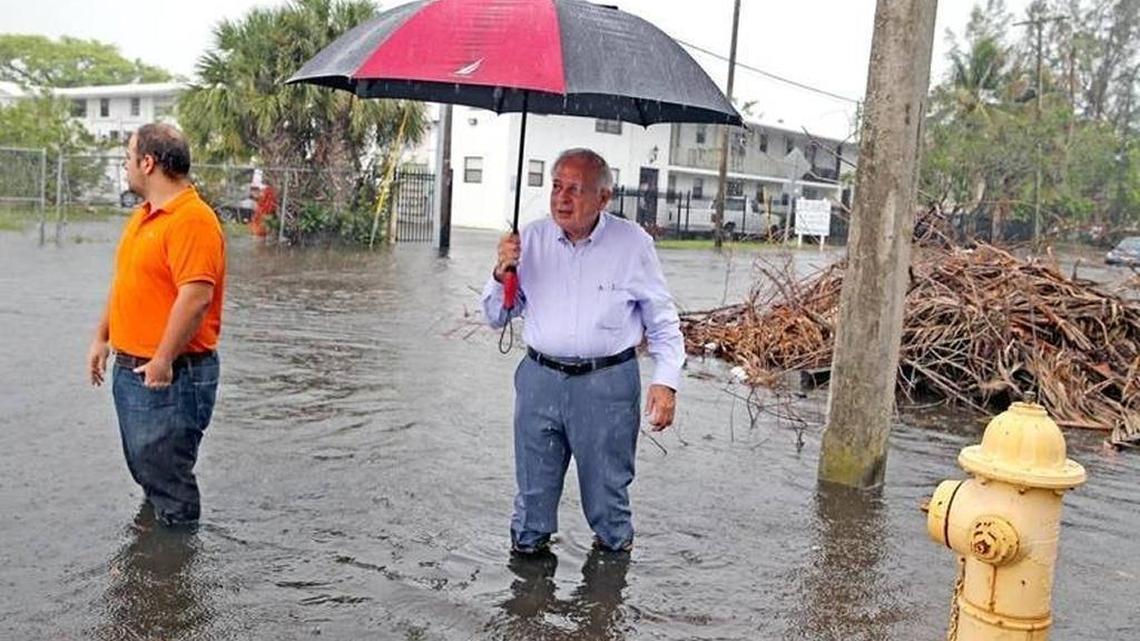 Miami Mayor Tomás Regalado holds an umbrella in an area of Shorecrest where the October king tides caused severe flooding. Voters passed the mayor’s $400 million Miami Forever bond Tuesday, nearly half of which will pay to brace the city against sea rise.