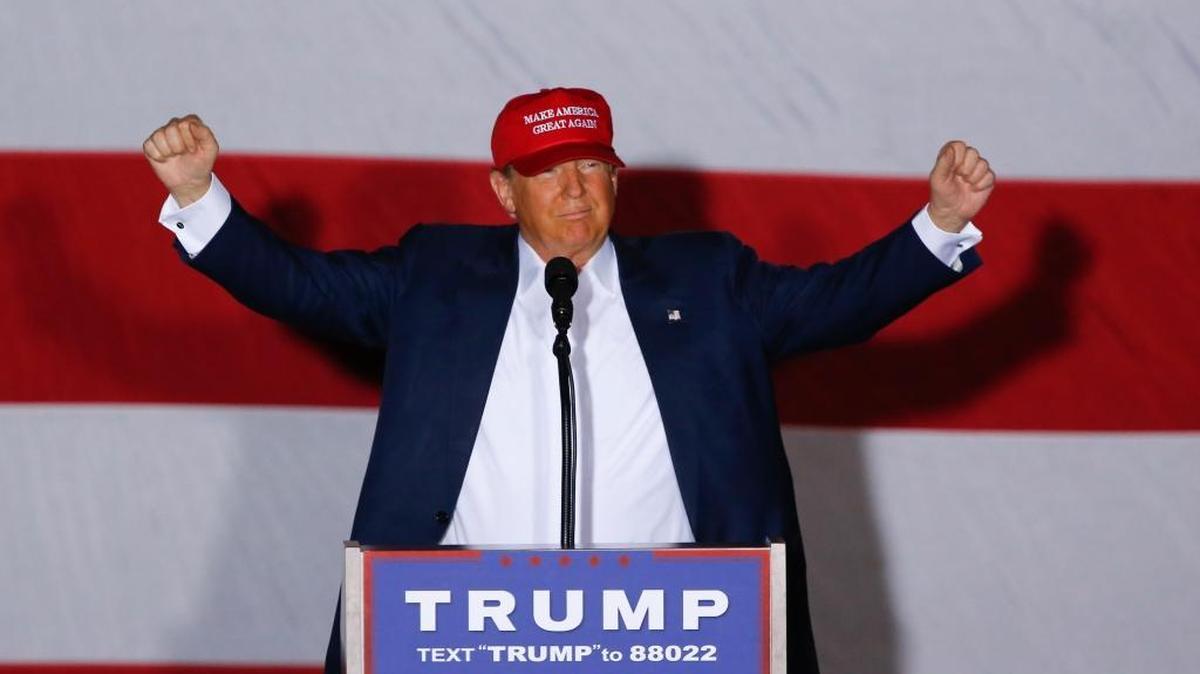 Republican presidential candidate Donald Trump raises his arms during a campaign rally in Boca Raton Sunday, March 13, 2016.