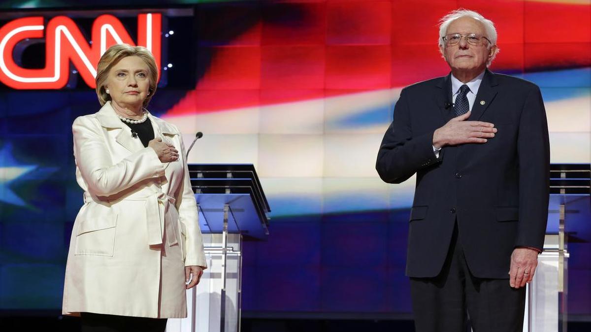 Democratic presidential candidates Sen. Bernie Sanders, I-Vt., right, and Hillary Clinton wait for the singing of the National Anthem during the CNN Democratic Presidential Primary Debate at the Brooklyn Navy Yard Thursday, April 14, 2016, New York.