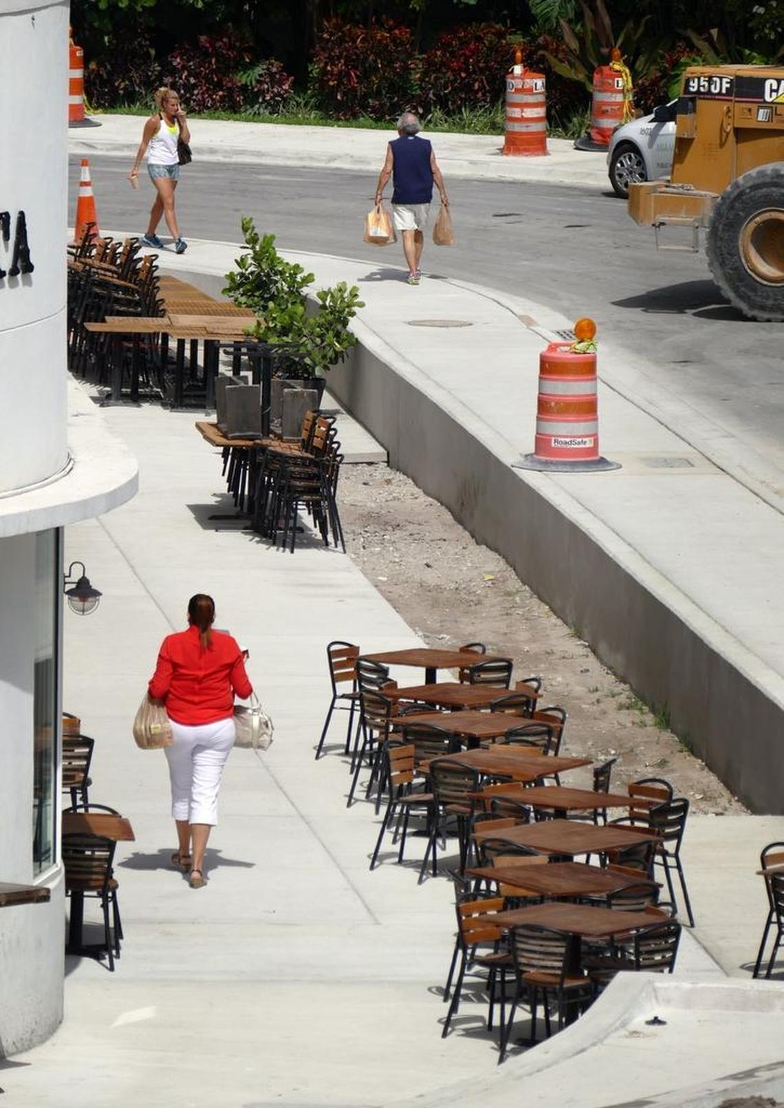 Pedestrians in the Sunset Harbour neighborhood of Miami Beach navigate elevated street-level sidewalks to safeguard the city from sea-level rise.