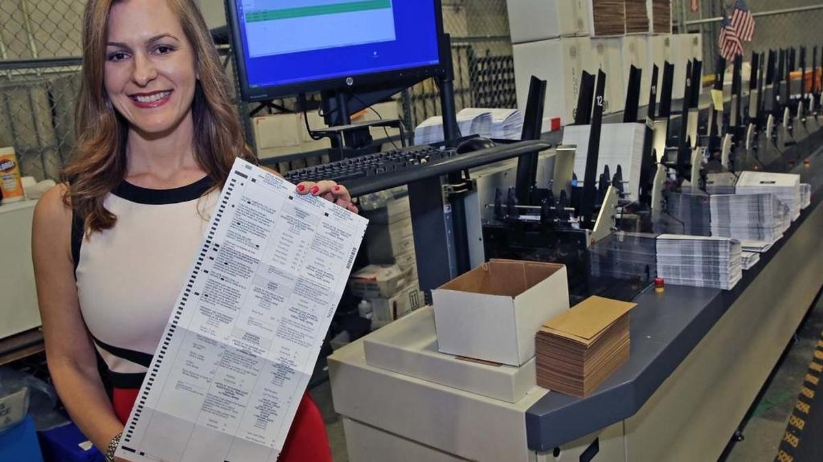 Christina White, Miami-Dade Supervisor of Elections, stands in front of a Reliavote System Machine, which processes inserts and handles the return ballots, tracks them and makes sure everybody that has requested a ballot gets a ballot at the Miami-Dade Elections Department in Doral on Thursday, October 27, 2016