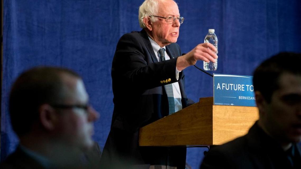 Democratic presidential candidate Bernie Sanders holds up a bottle of water as he speaks about contaminated water during a community forum at Woodside Church in Flint, Mich., on Thursday.