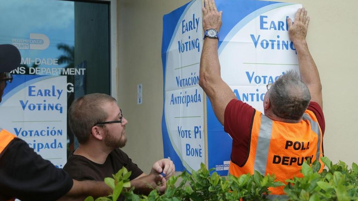 Employees hang early voting signs as they conduct early voting training for the Nov. 8 general election at the Miami-Dade County Elections Department, Wednesday, Oct. 12, 2016,i n Doral.