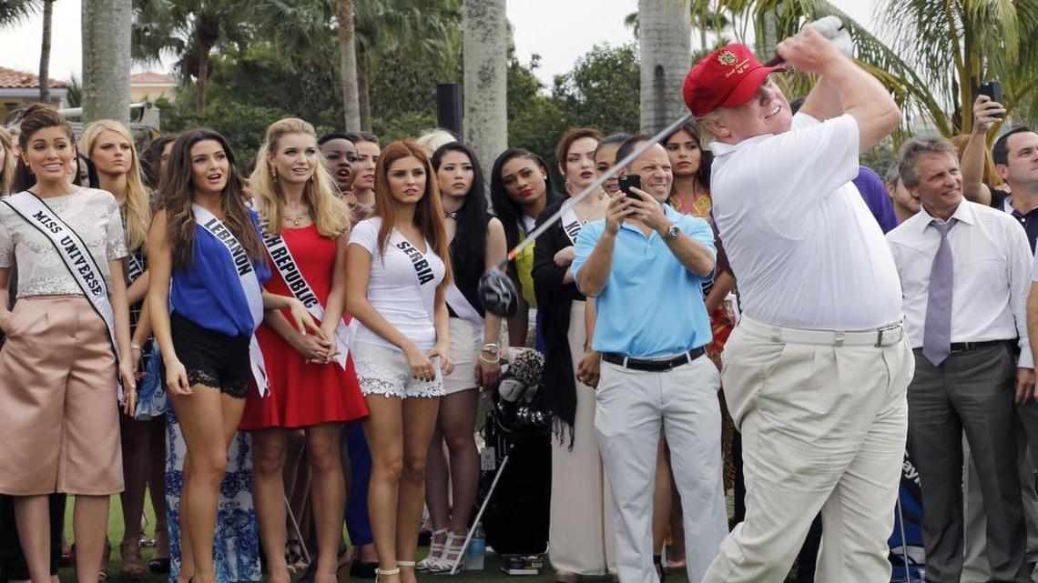 
Donald Trump tees off at the Red Tiger golf course at Trump National Doral in January, with Miss Universe contestants standing behind him.
