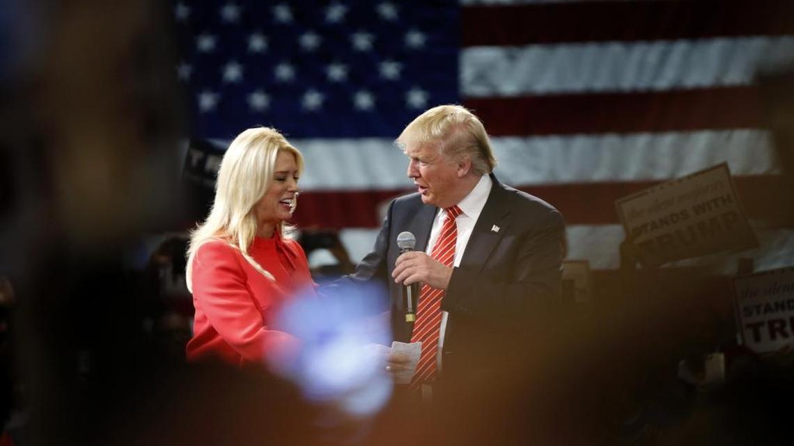 Republican presidential candidate Donald Trump is greeted by Florida Attorney General Pam Bondi as she introduces him to speak at a campaign event in Tampa, Monday, March 14, 2016.
