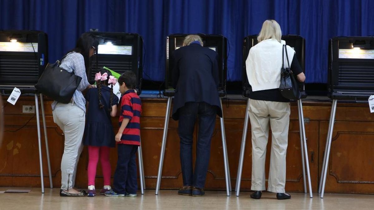 Ana Fernandez de Castro votes with her twin children, Abigail and Benjamin, 5, in Miami Shores on Tuesday.
